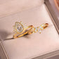 Angled view of gold pear cut moissanite lotus halo and sunburst crown ring set in box.
