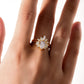 Model wearing pear cut moissanite lotus halo ring set with sunburst crown band.