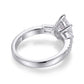 Side profile showing high basket prong setting and pave band on pear moissanite ring.