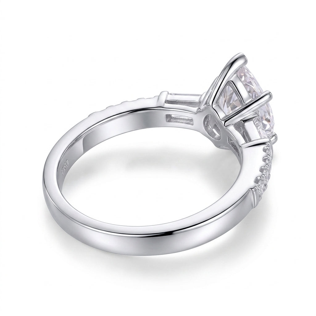 Side profile showing high basket prong setting and pave band on pear moissanite ring.