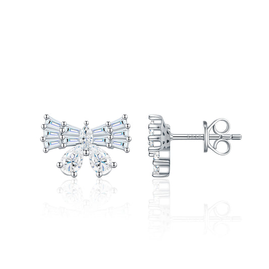Symmetrical studio display of platinum plated baguette moissanite bowknot stud earrings with pear cut ribbon accents.