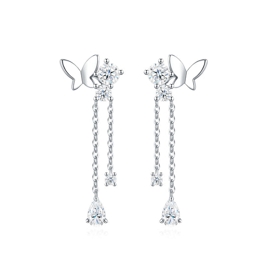 Symmetrical studio display of platinum plated butterfly moissanite dangle earrings with dual tassel chains and pear cut drop.
