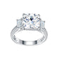 Symmetrical studio view of a platinum plated cushion cut moissanite ring with tapered baguette side stones and triple row pave shank.