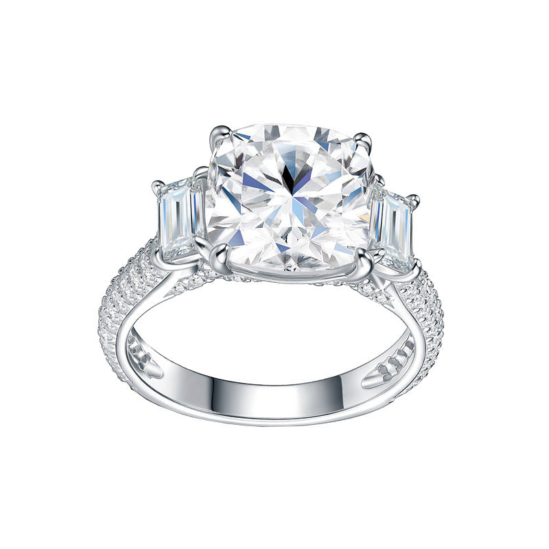 Symmetrical studio view of a platinum plated cushion cut moissanite ring with tapered baguette side stones and triple row pave shank.