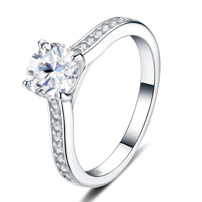 Three-quarter studio catalog perspective of a platinum plated round brilliant moissanite cathedral engagement ring with pave side stones.