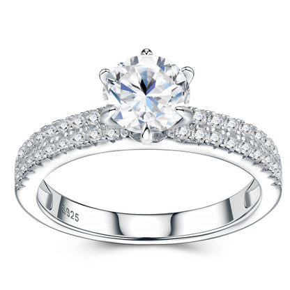 Symmetrical studio view of a platinum plated round cut moissanite solitaire ring with double row pave shank and six-prong mount.