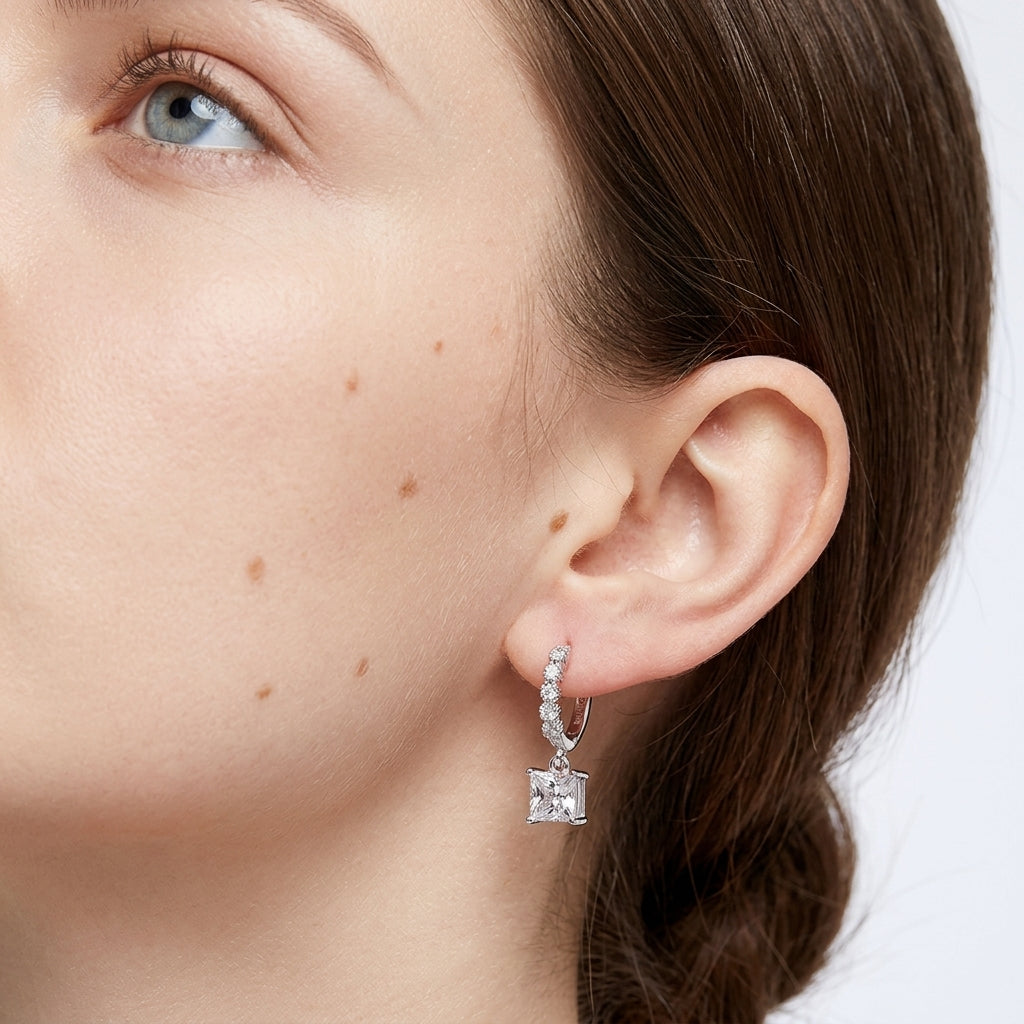 Model wearing 2.4ctw princess cut diamond dangle huggie hoop earrings.