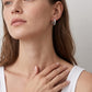 Model wearing princess cut moissanite channel set huggie hoop earrings