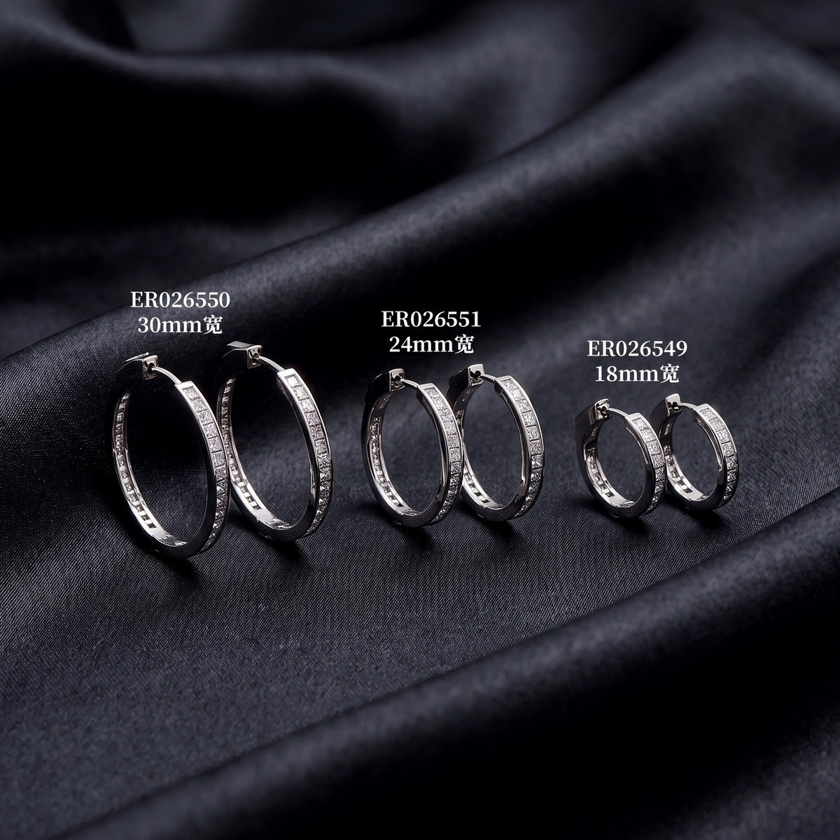 Princess cut moissanite channel set huggie hoop earrings in various hoop sizes on dark silk background   