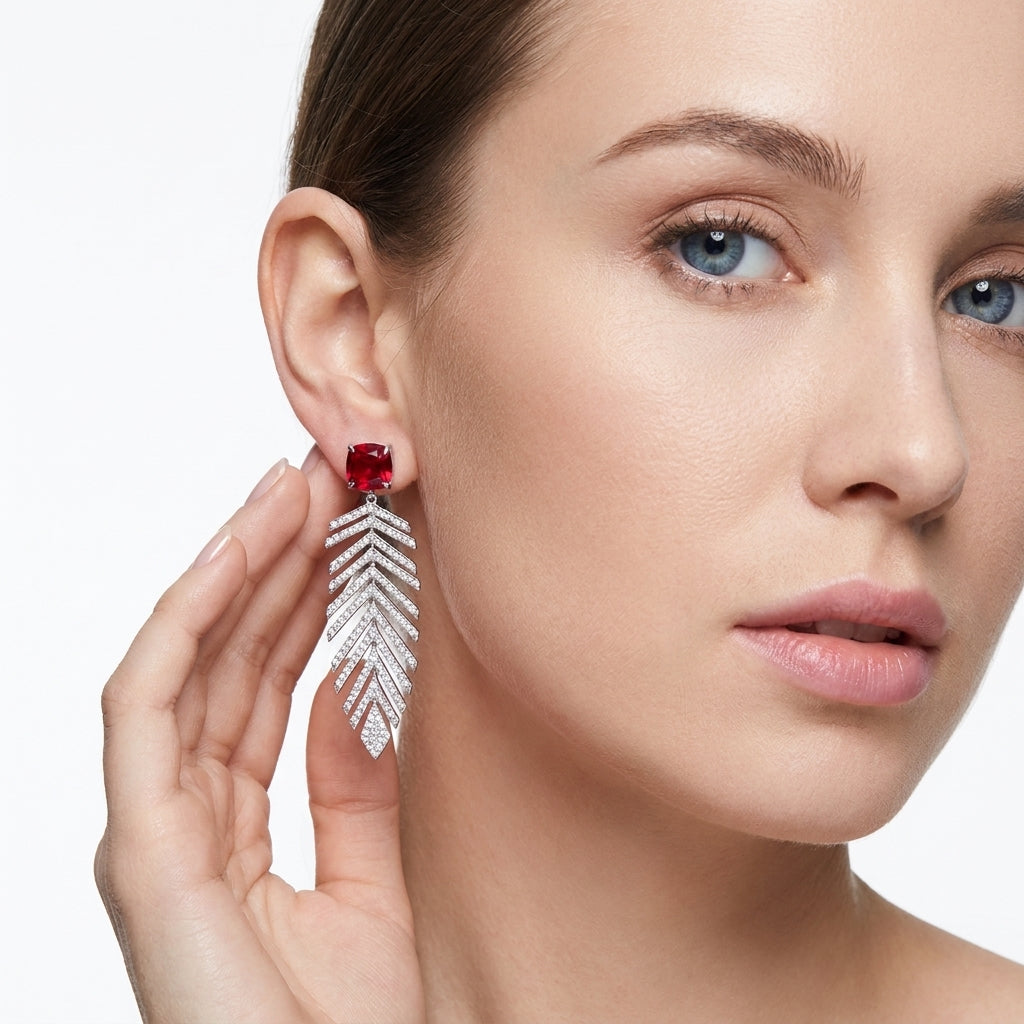 Side profile lifestyle view of an elegant model wearing classic ruby botanical feather drop earrings.