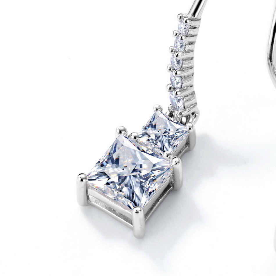 Close-up view of graduated princess cut two-stone dangle pendant showing pavé-set line hook.