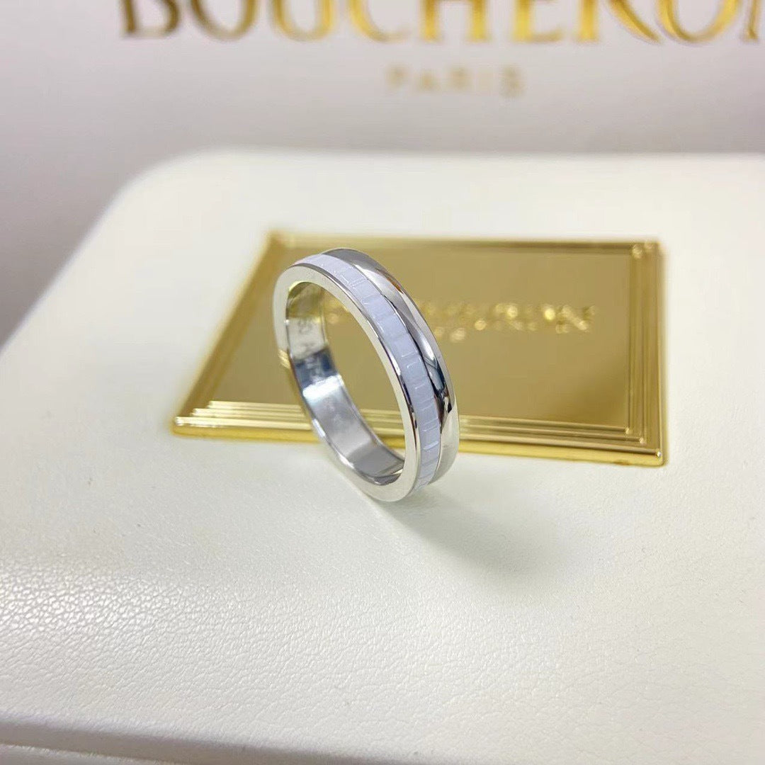 Close-up shot of a contemporary Quatre inspired double white HyCeram ceramic ring in a 925 silver finish on a luxury box.
