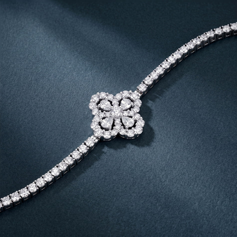 5.52 CTW diamond quatrefoil flower tennis bracelet displayed on dark blue background.