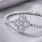 Close-up view of pear-cut quatrefoil flower cluster and tennis link chain on bracelet.
