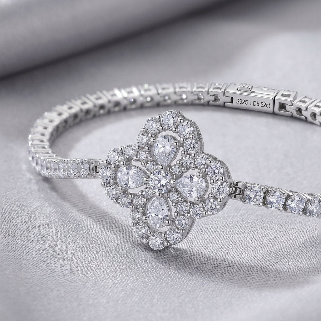 Close-up view of pear-cut quatrefoil flower cluster and tennis link chain on bracelet.