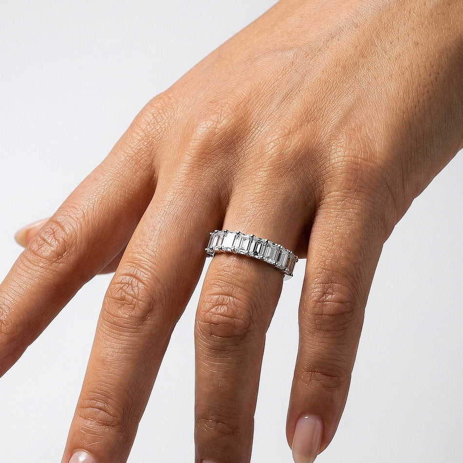 Full hand view of model wearing radiant emerald cut anniversary band ring.