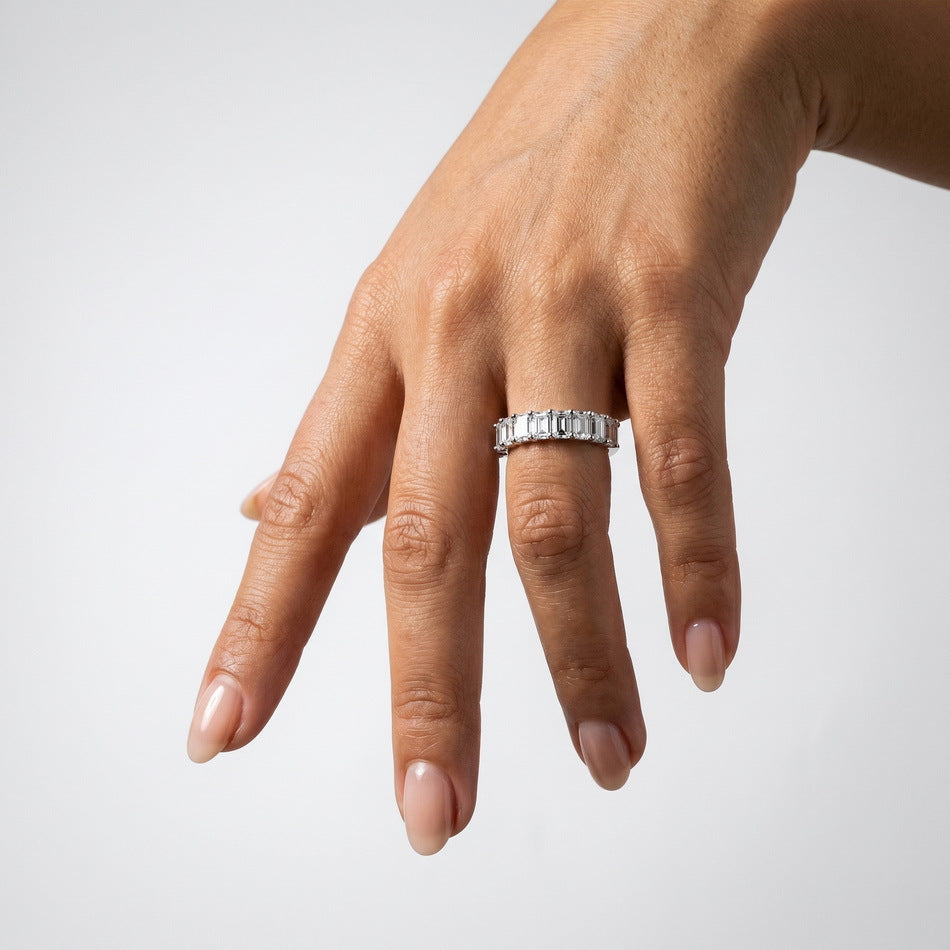 Alternative hand angle view of emerald cut diamond simulant half-eternity ring.
