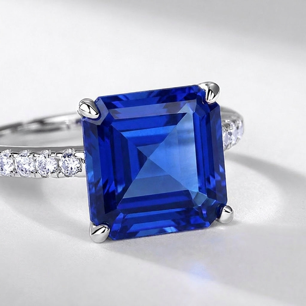 Macro close-up shot capturing the intense stone fire and step-cut facets of the square blue sapphire ring.