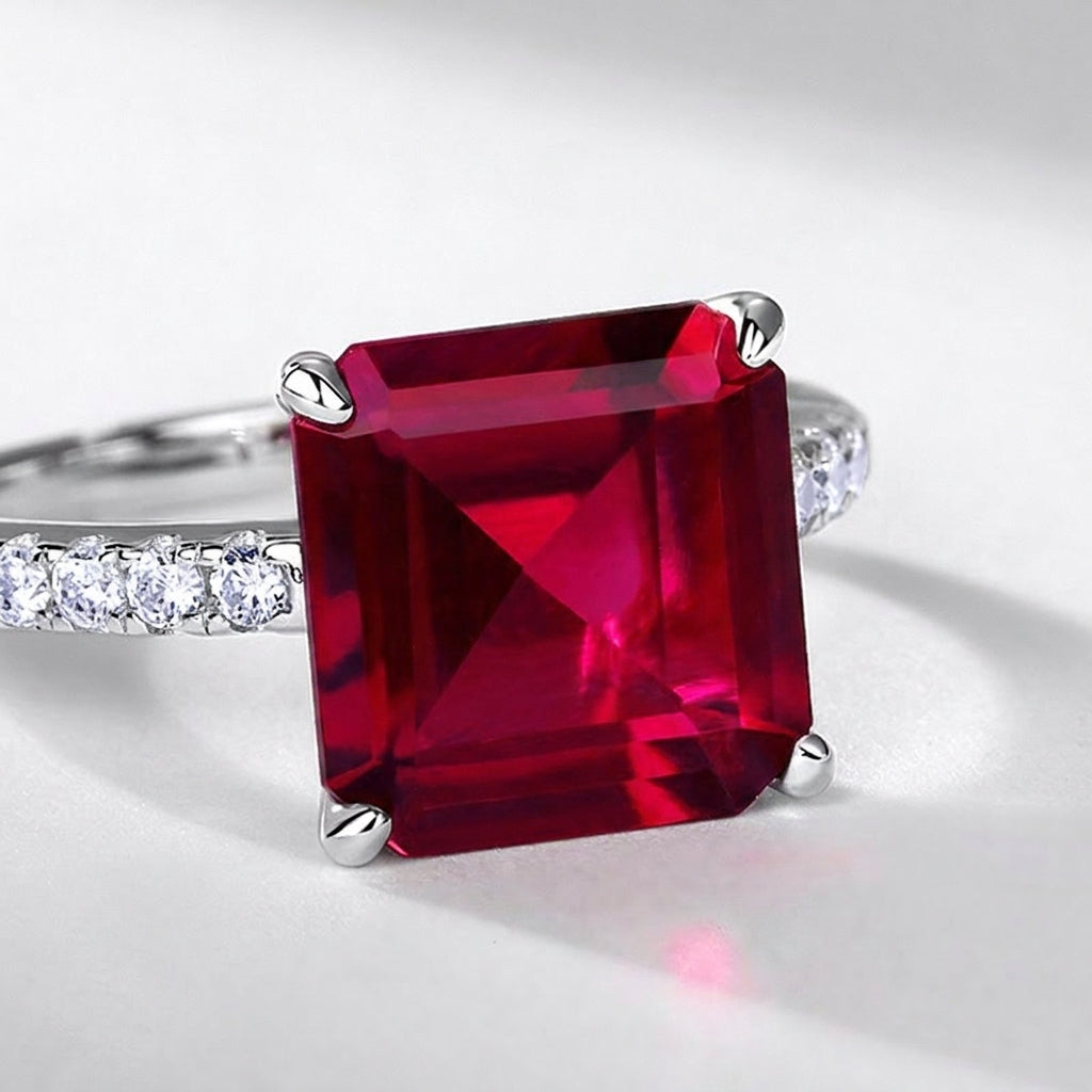 Macro close-up shot capturing the intense stone fire and step-cut facets of the square ruby ring.