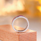 Full circular view of rainbow baguette cut channel set eternity band showing open under-gallery.