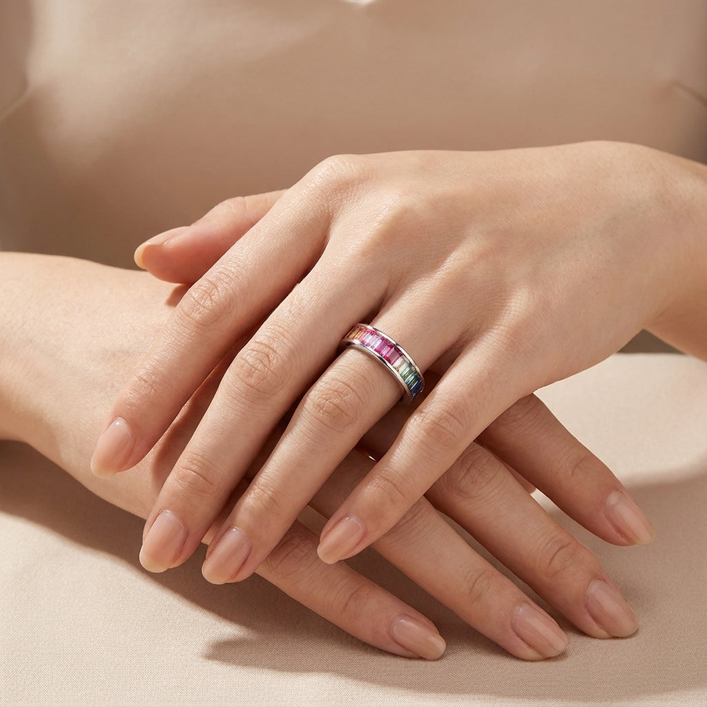 Model wearing rainbow baguette cut multi-color gemstone channel set ring.