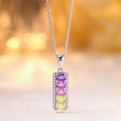 Hanging view of rainbow emerald cut multi-color gemstone vertical bar pendant with cable chain.