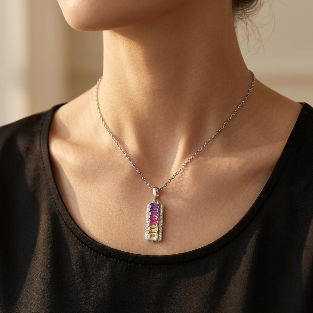Model wearing rainbow emerald cut multi-color gemstone vertical bar pendant necklace on neck.