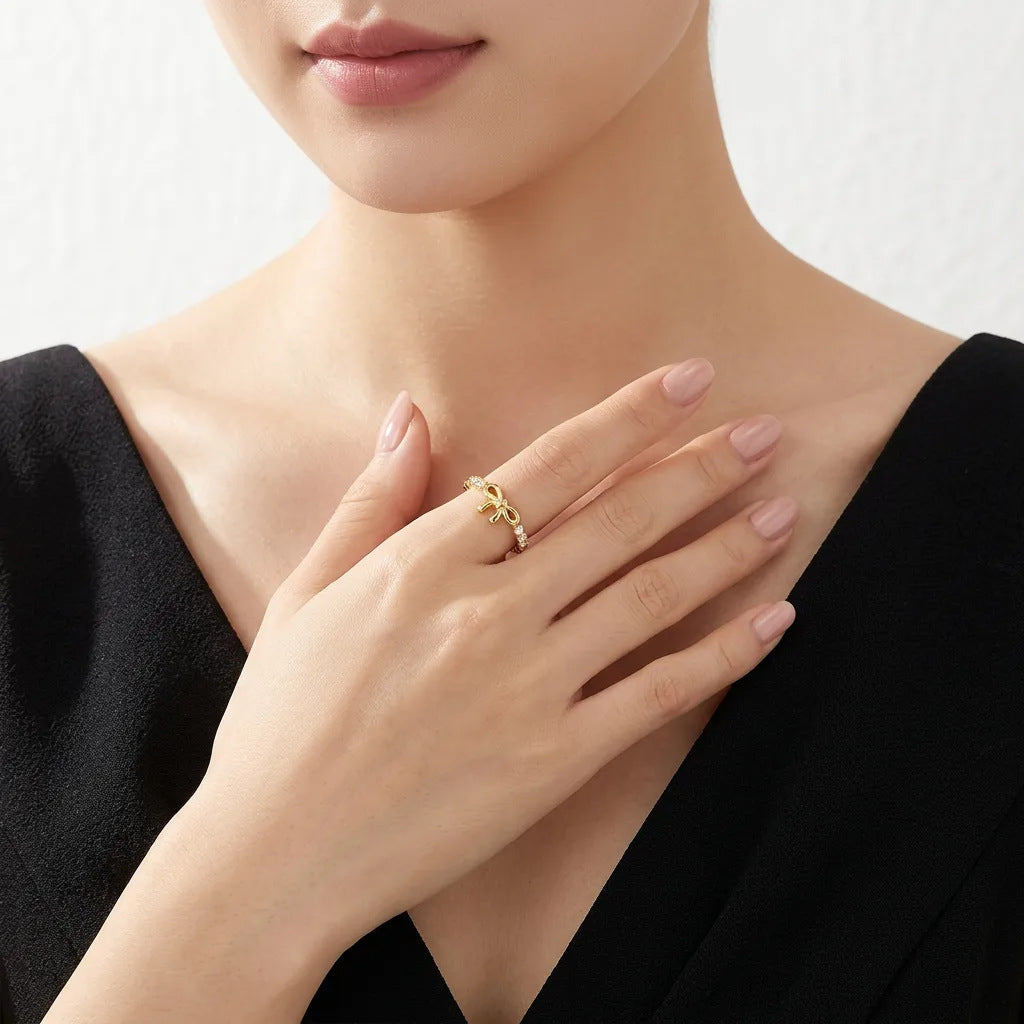 Fashion model in a black dress wearing the elegant gold bow knot stacking ring.