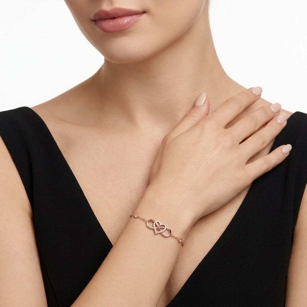 Close-up view of rose gold infinity heart pavé moissanite bracelet styled with black outfit.