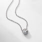 Round bezel set lab grown diamond solitaire necklace lying on light background.