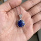 Blue gemstone pendant on a chain held in a hand
