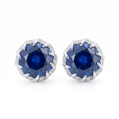 Front view of classic round-cut brilliant blue sapphire stud earrings on white backdrop.