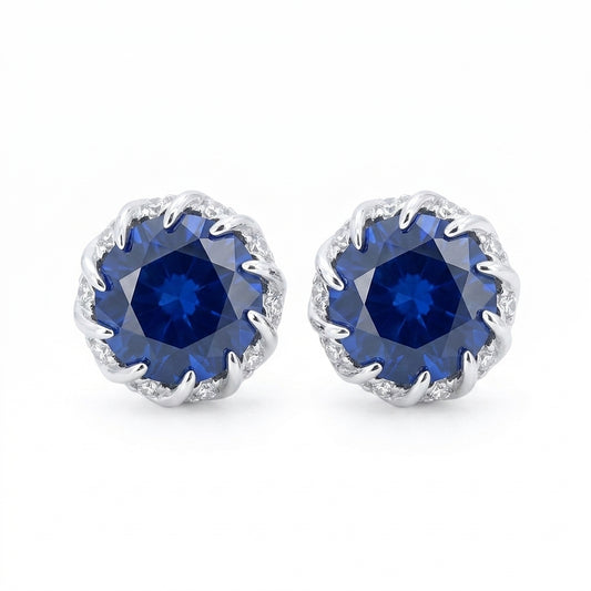 Front view of classic round-cut brilliant blue sapphire stud earrings on white backdrop.