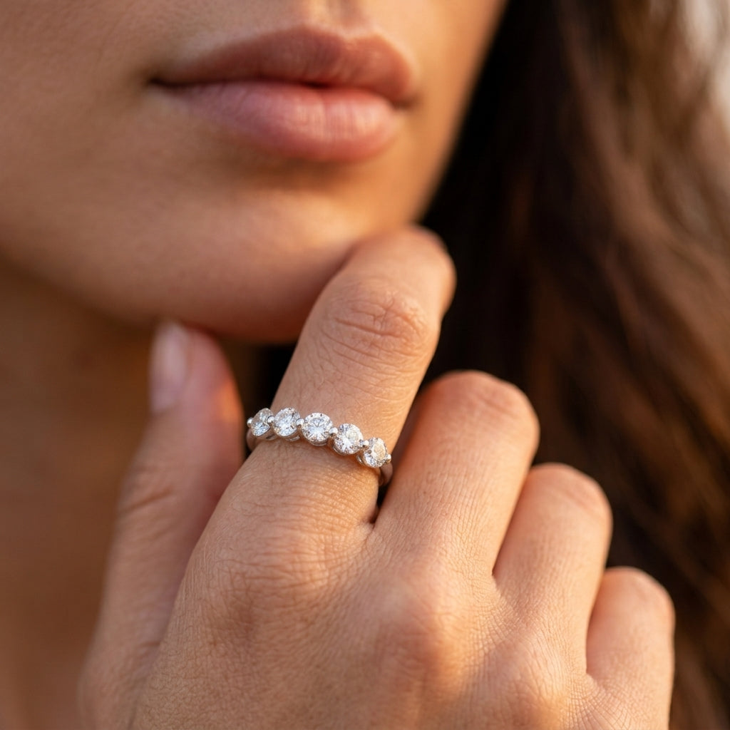 Model wearing round brilliant diamond simulant 7-stone anniversary wedding band ring.