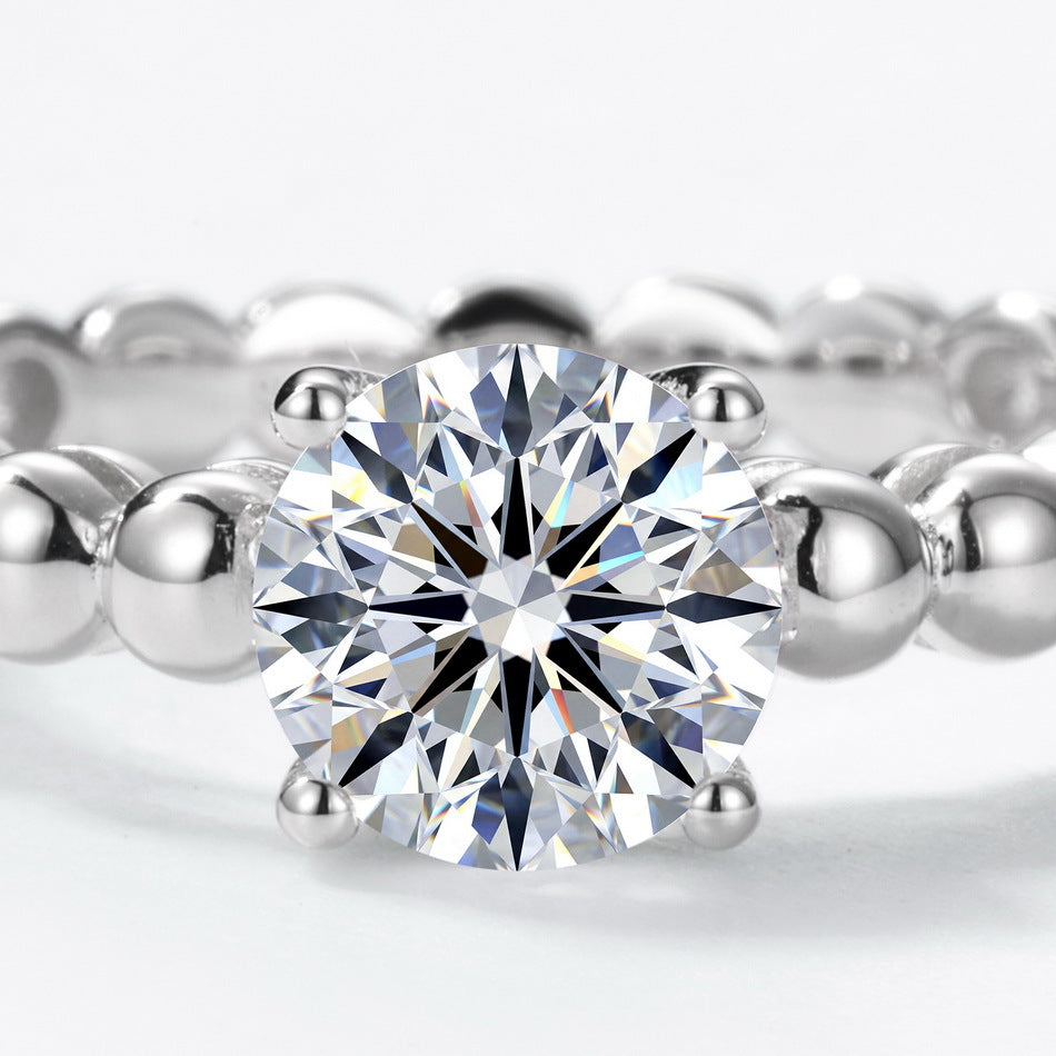 Extreme close-up shot showing center round brilliant stone and beaded bubble band.
