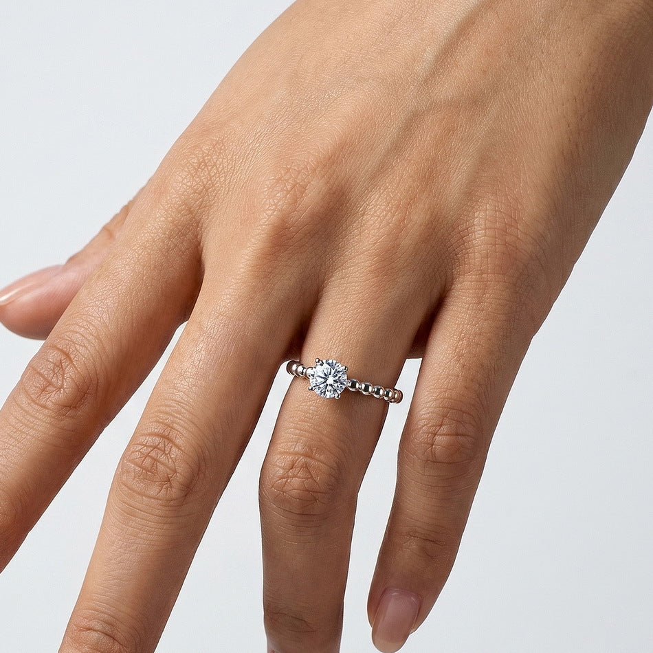 Full hand view of model wearing round brilliant bubble band solitaire engagement ring.