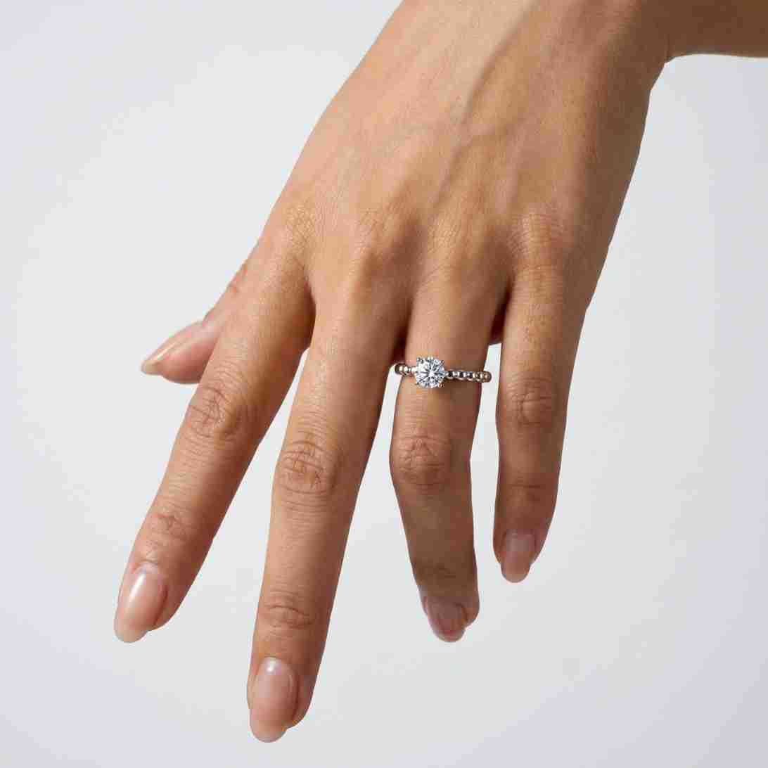 Alternative hand angle view of round brilliant solitaire bubble band ring.