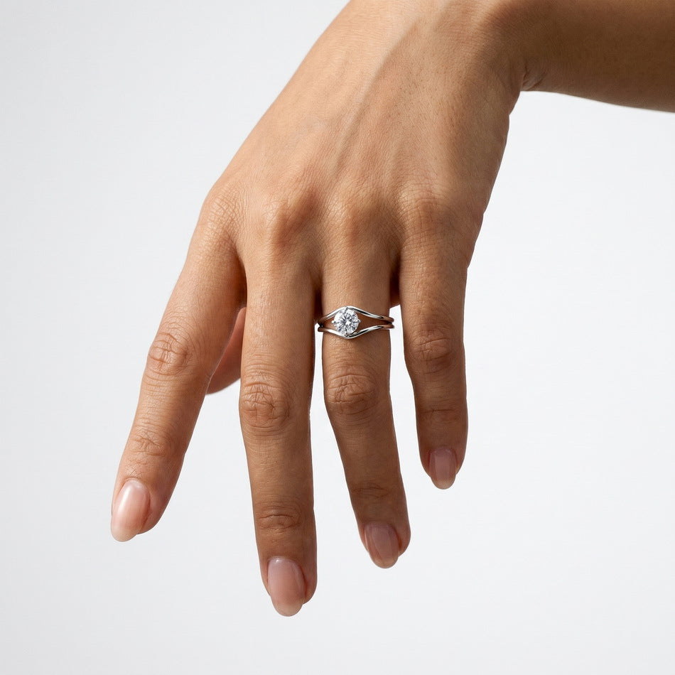 Full hand shot of model wearing round brilliant diamond simulant swirl bypass ring.