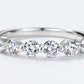 Extreme close-up showing shared-prong setting of round brilliant diamond simulant wedding band.