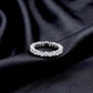 Round brilliant lab grown diamond eternity wedding band resting flat on dark black silk