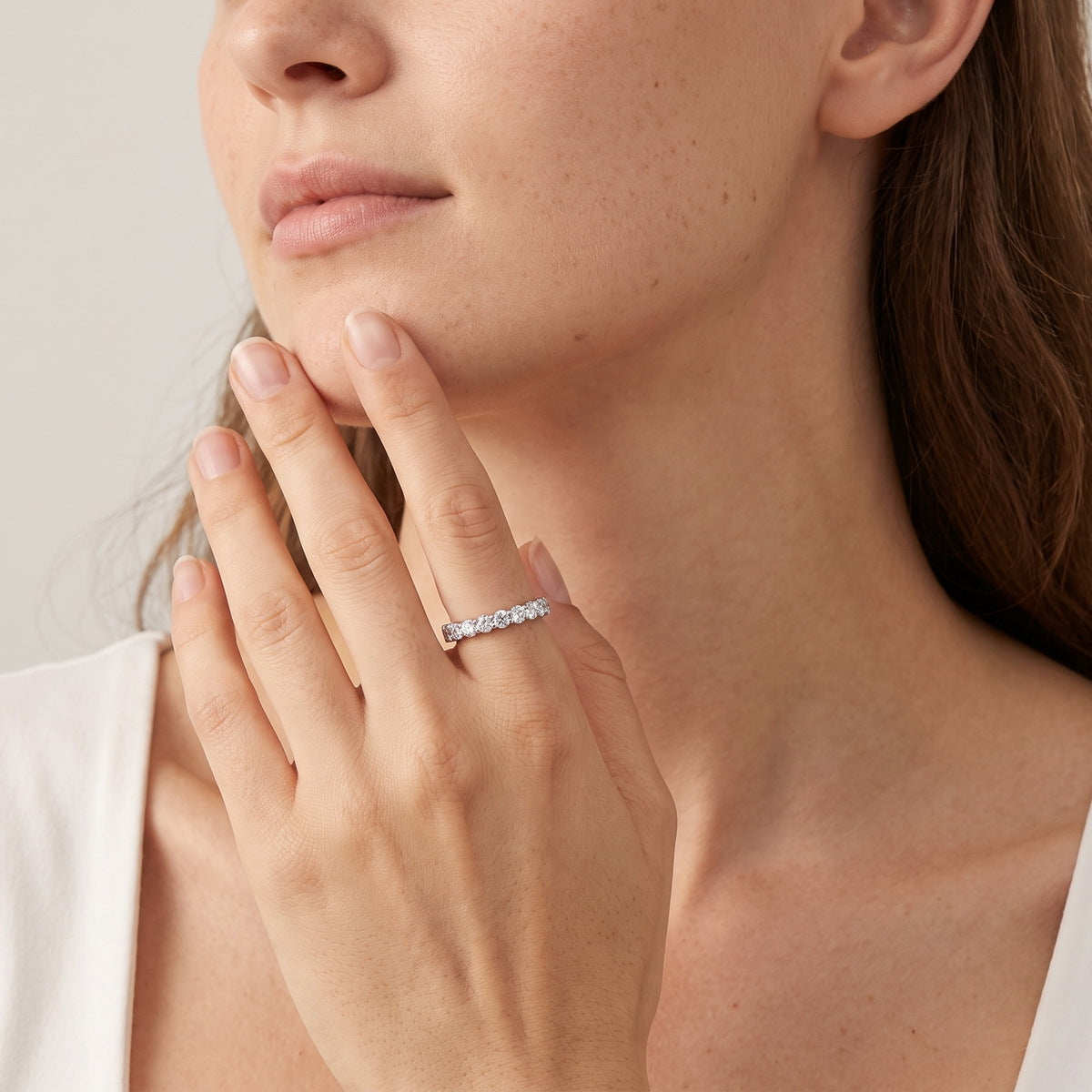 Model wearing classic round cut lab grown diamond eternity ring on finger