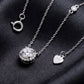 Close up view of round cut lab grown diamond halo pendant and S925 heart tag on dark black silk