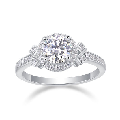 Round cut moissanite halo engagement ring with geometric diamond-shaped motif shoulders and pave band on white background.