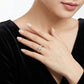 Close-up view of round moissanite solitaire double pavé ring set styled with black dress.