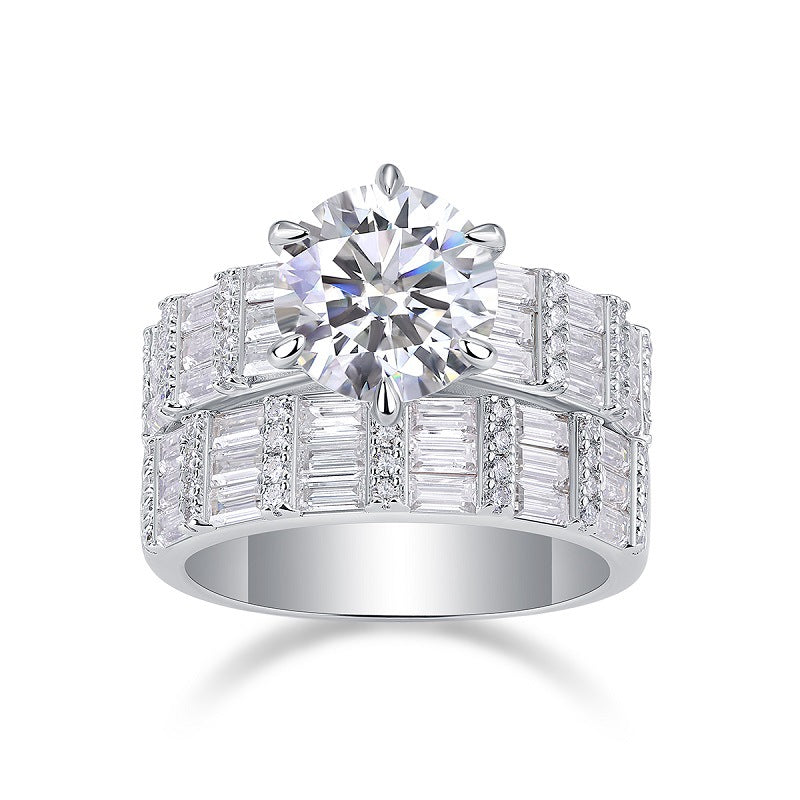 Round cut moissanite engagement ring with wide multi-row baguette stacking band on white background.