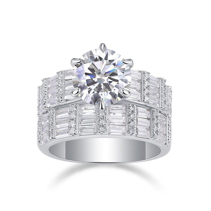 Round cut moissanite engagement ring with wide multi-row baguette stacking band on white background.