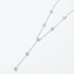 Angled view of round diamond bezel-set station Y-necklace on white background.