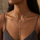 Model wearing round diamond bezel-set station Y-lariat necklace with dark camisole.