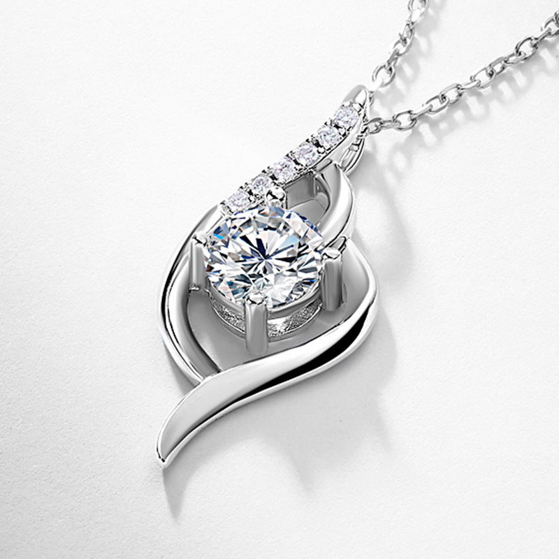 Round diamond intertwined swirl solitaire pendant displayed on textured dark background.