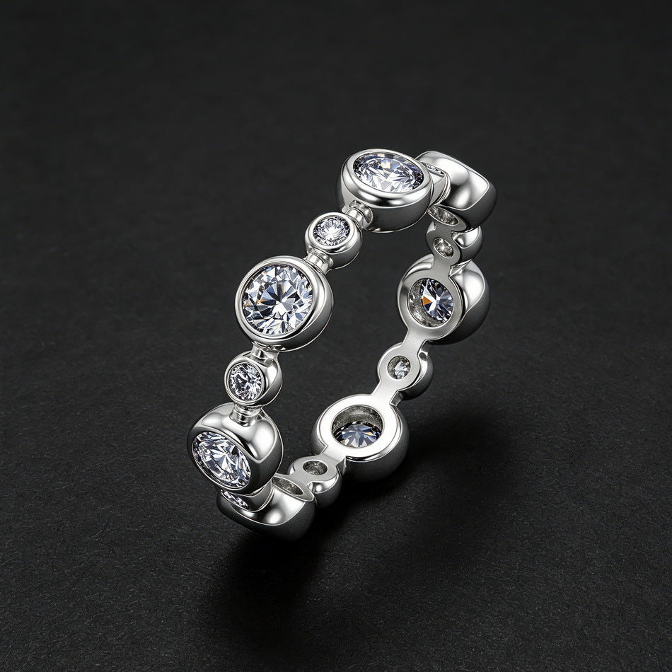 Angled standing perspective view of round lab diamond bezel set bubble eternity band on dark background.